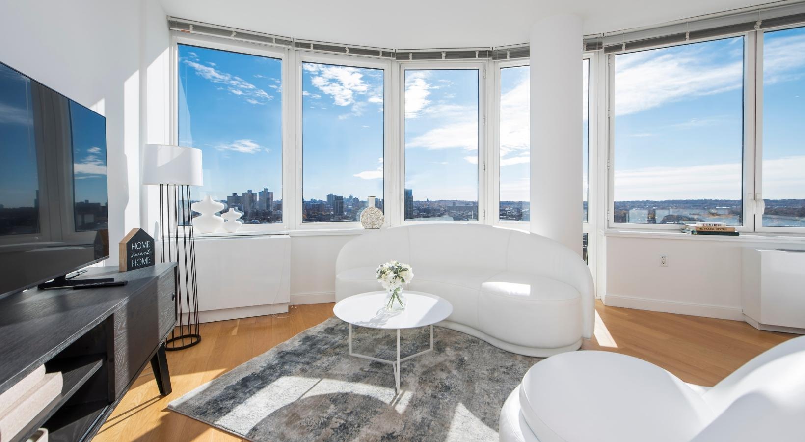 Wide open living areas flooded with natural light a room with a large window and a table with a chair and a couch