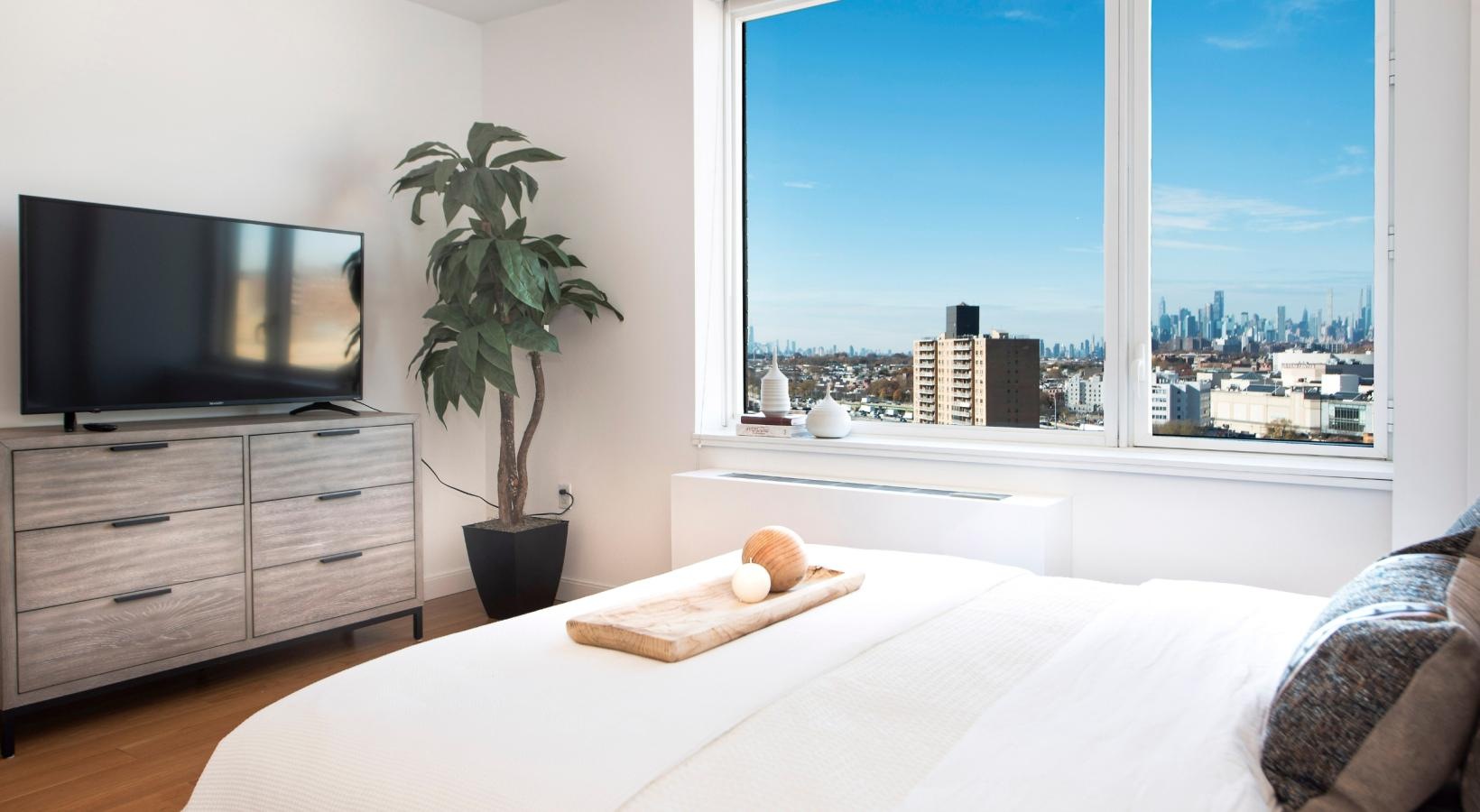 Beautiful bedrooms to fit every need a bed with a tv and a plant on it