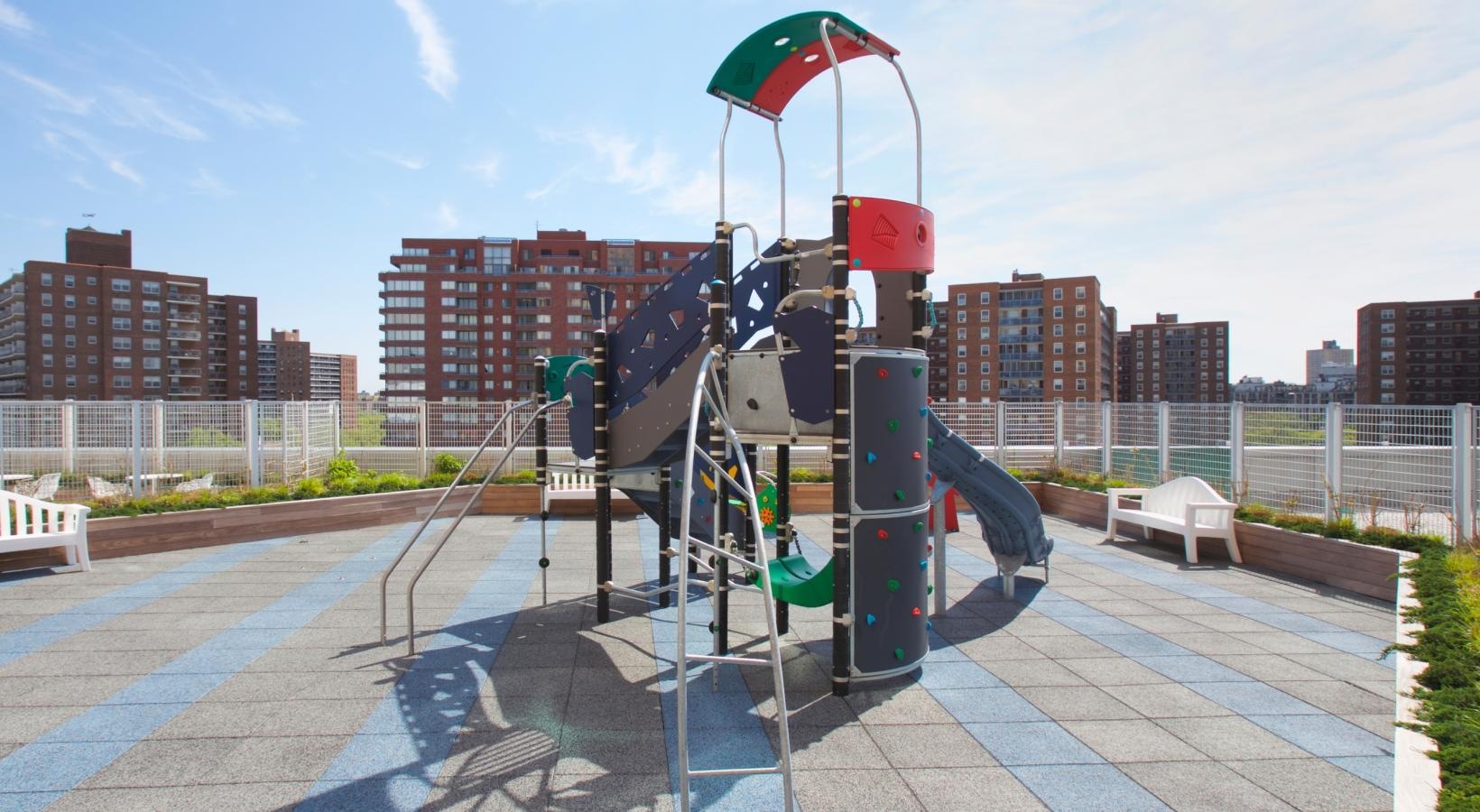 Settle into comfort at The Alexander a playground with a slide and a flag
